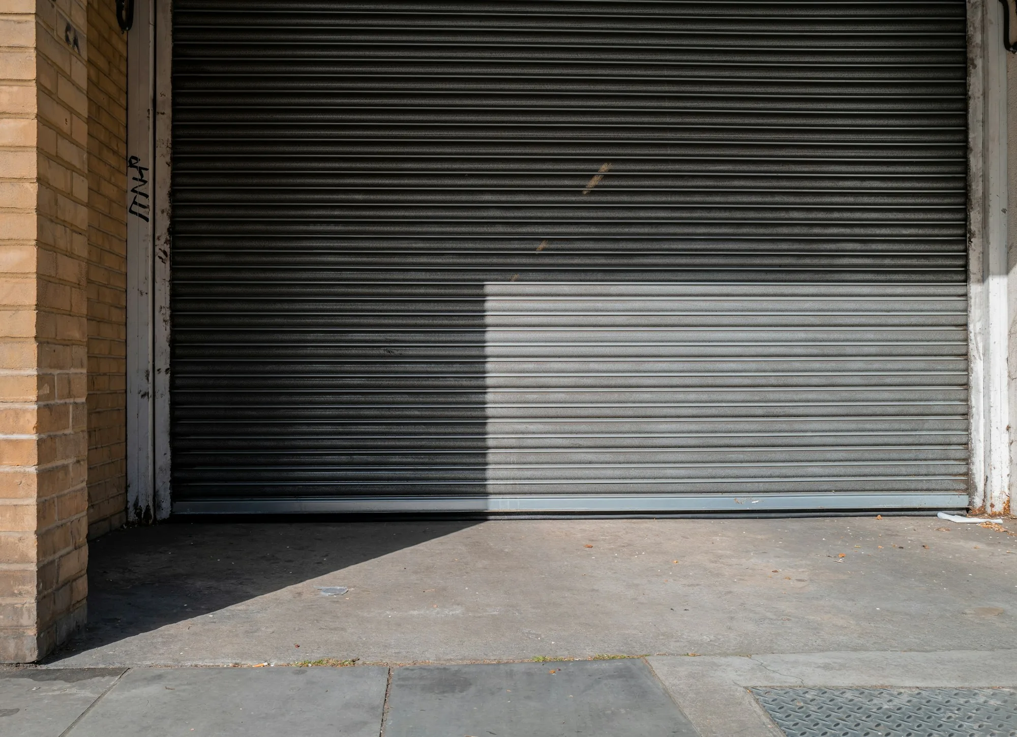 Closed gray rolling steel door on a commercial building